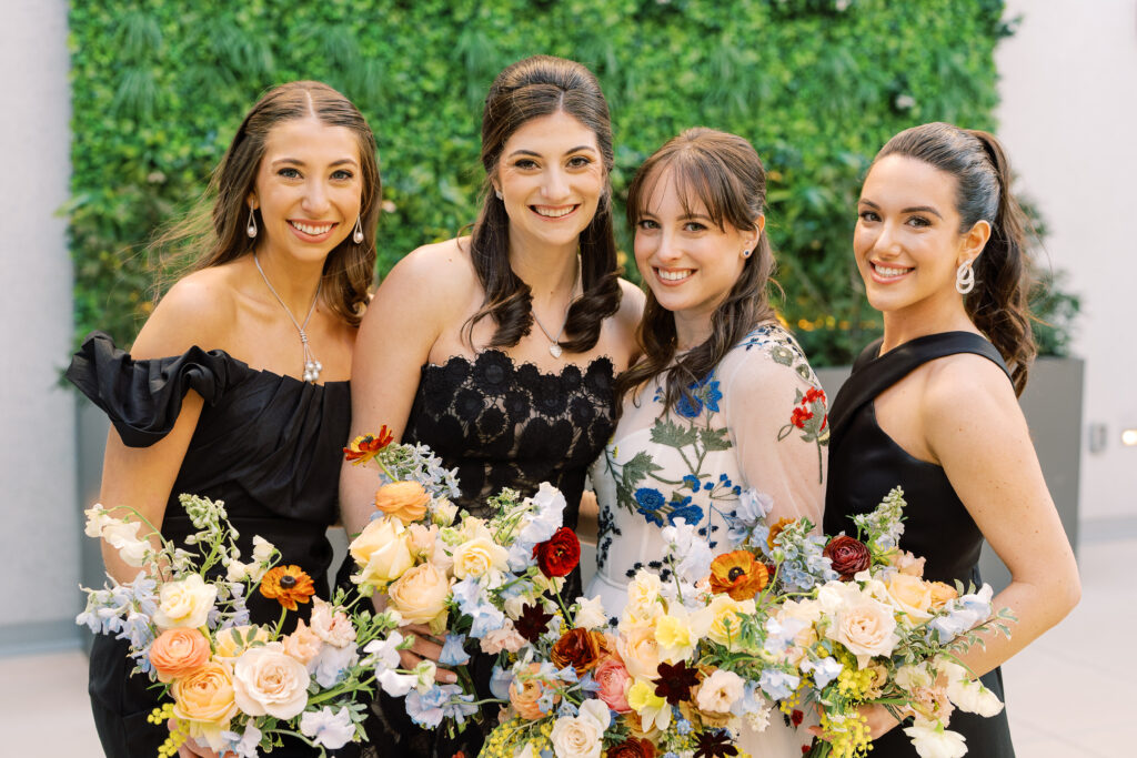 This bridal bouquet features a stunning mix of flowers in a pastel color palette, creating an elegant and romantic look. The combination of soft pastels with darker accents provides a beautiful contrast, while the mix of shapes and textures adds visual interest and depth. Bridesmaids’ bouquets accenting bridal bouquet. Winter wedding in downtown Nashville. Design by Rosemary & Finch Floral Design. 