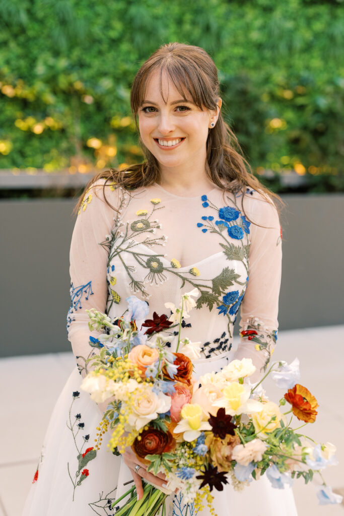 This bridal bouquet features a stunning mix of flowers in a pastel color palette, creating an elegant and romantic look. The combination of soft pastels with darker accents provides a beautiful contrast, while the mix of shapes and textures adds visual interest and depth. Bridesmaids’ bouquets accenting bridal bouquet. Winter wedding in downtown Nashville. Design by Rosemary & Finch Floral Design. 