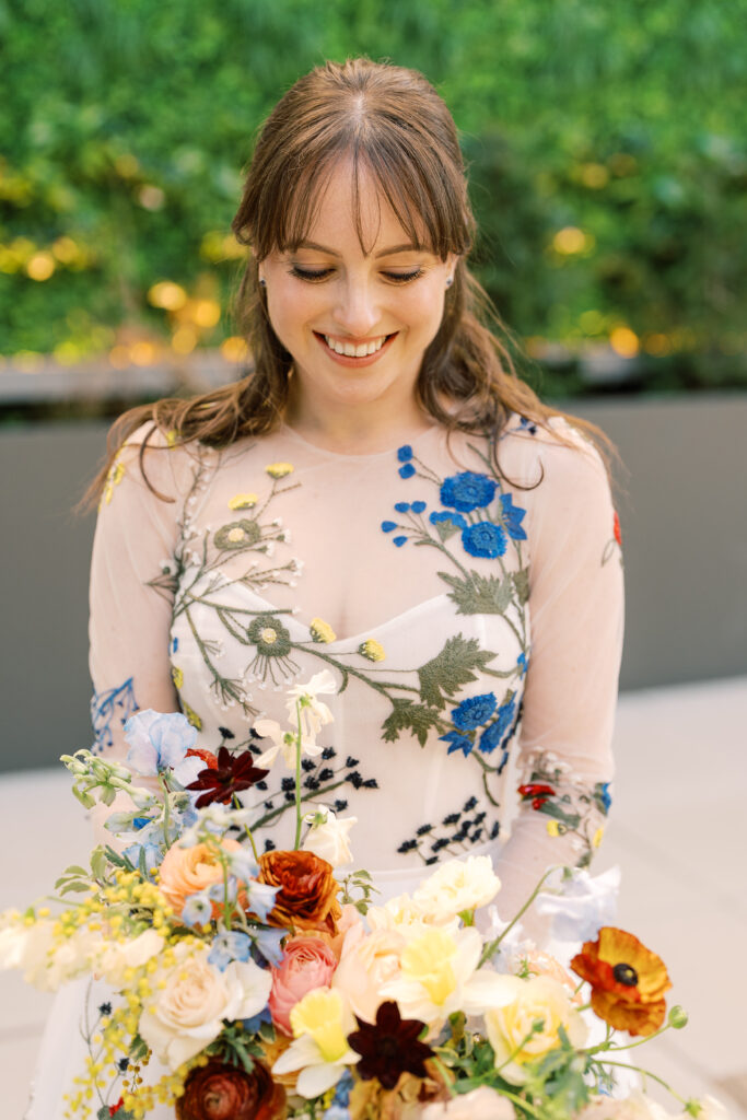 This bridal bouquet features a stunning mix of flowers in a pastel color palette, creating an elegant and romantic look. The combination of soft pastels with darker accents provides a beautiful contrast, while the mix of shapes and textures adds visual interest and depth. Bridesmaids’ bouquets accenting bridal bouquet. Winter wedding in downtown Nashville. Design by Rosemary & Finch Floral Design. 