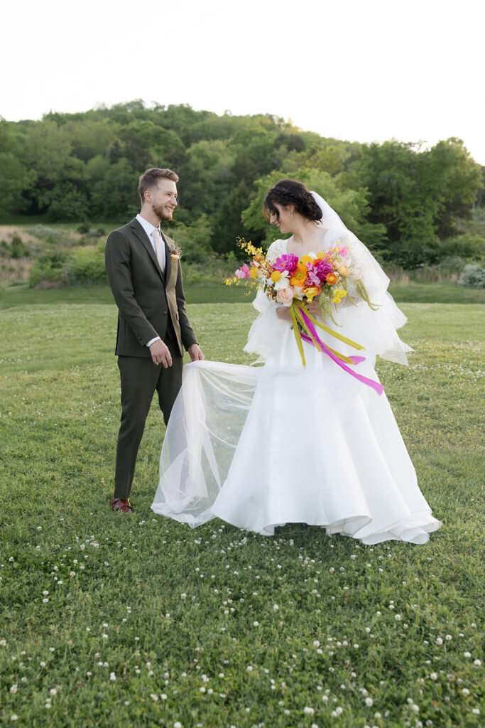 Vibrant and colorful bridal bouquet with flowers that includes lush, fully bloomed peonies in rich magenta, complemented by bright orange and yellow poppies. Summer bridal and bridesmaids’ bouquet with unique and bold spring colors. Whimsical wedding floral with statement making colors. Design by Rosemary & Finch Floral Design. 