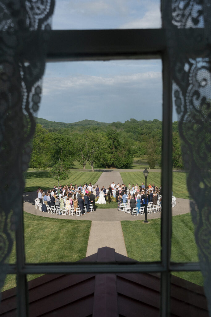 Floral ground meadows for spring wedding ceremony. Unique circle ceremony for outdoor Tennessee wedding. Ceremony floral installation includes a variety of greenery and flowers, with dominant hues of yellow and orange, accented by soft pink and white roses. Unique vibrant spring florals. Design by Rosemary & Finch Floral Design in Nashville, TN.