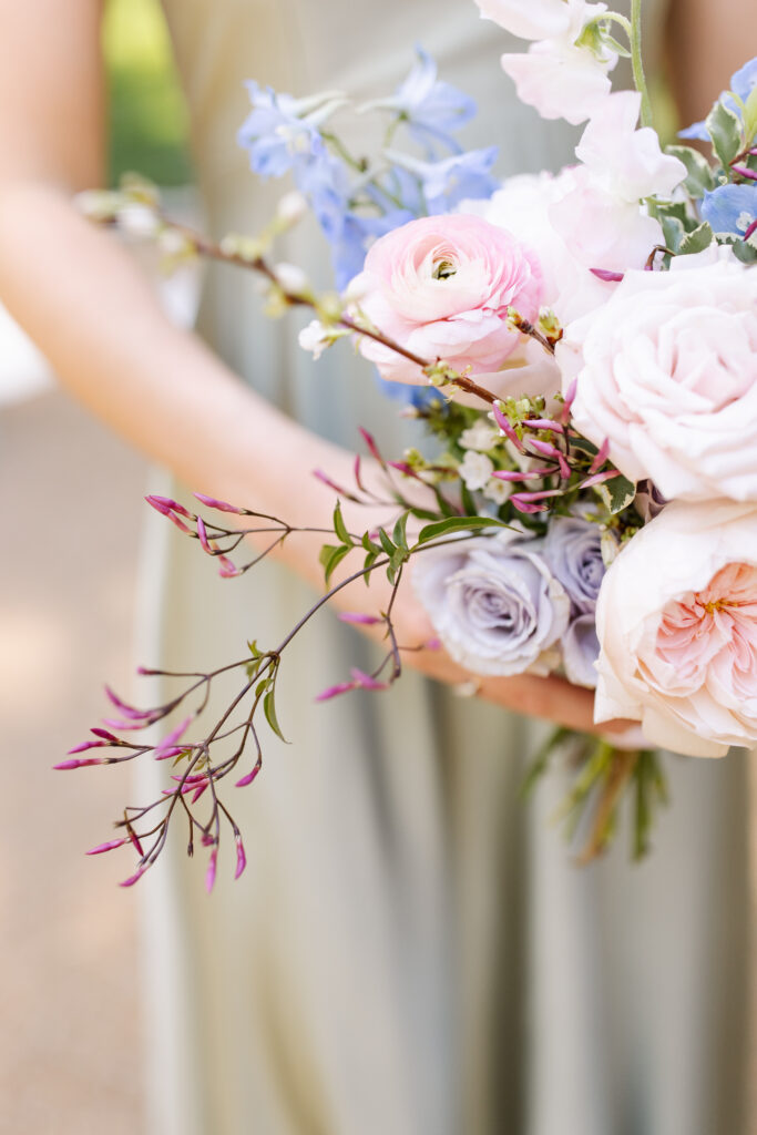 Elegant bridal bouquet in soft pastel colors, including shades of pink, white, and lavender. Mix of roses, peonies, and other delicate blooms, accented with greenery. Lush garden style bridal bouquet for spring wedding. Bridesmaids’ bouquets accenting bridal. Design by Rosemary & Finch Floral Design in Nashville, TN. 