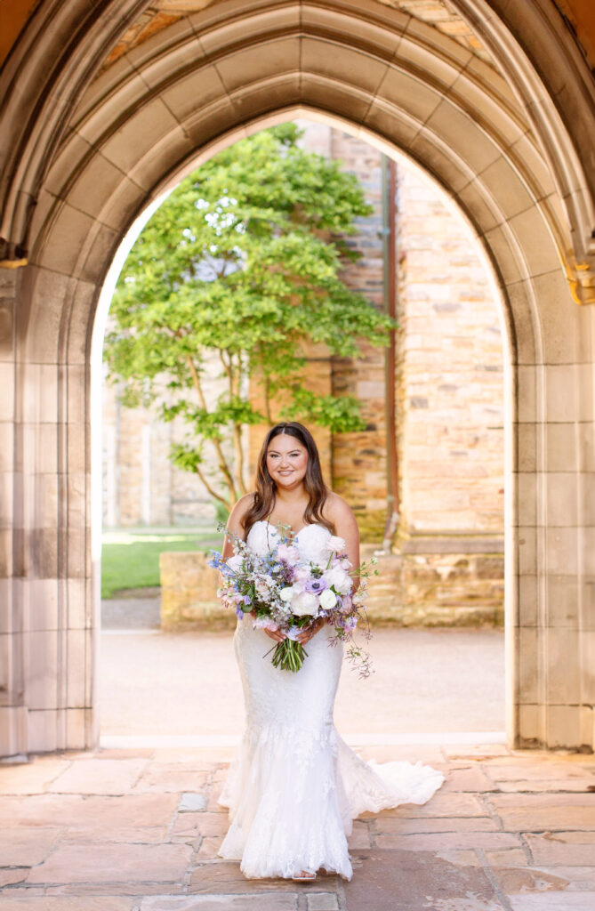 Elegant bridal bouquet in soft pastel colors, including shades of pink, white, and lavender. Mix of roses, peonies, and other delicate blooms, accented with greenery. Lush garden style bridal bouquet for spring wedding. Bridesmaids’ bouquets accenting bridal. Design by Rosemary & Finch Floral Design in Nashville, TN. 