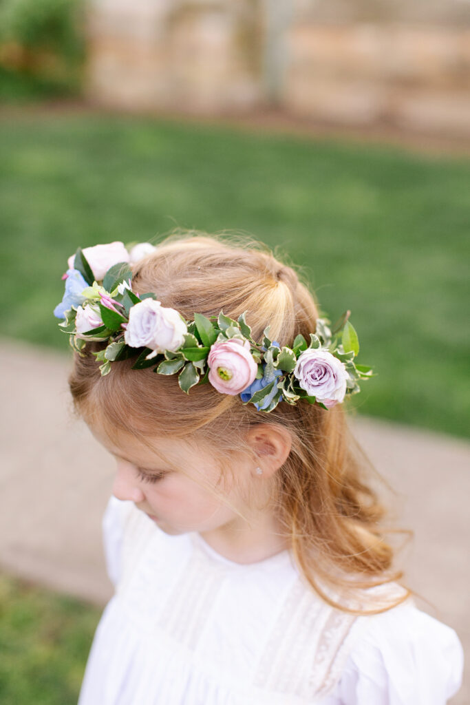 Delicate flower crown for spring wedding ceremony. Elegant pastels for spring wedding colors with ranunculus, peonies, and roses. Design elements of cherry tree, blue patterned linens, and custom art. Design by Rosemary & Finch Floral Design in Nashville, TN.