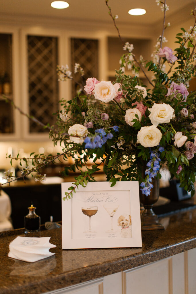 Garden inspired spring wedding in Nashville, TN. Pastel color palette for spring wedding which shades of pink, purple, lavender, and cream. Featuring lush white peonies, roses, anemones, and petal heavy florals. Design elements of cherry tree, blue patterned linens, and custom art. Design by Rosemary & Finch Floral Design in Nashville, TN. 