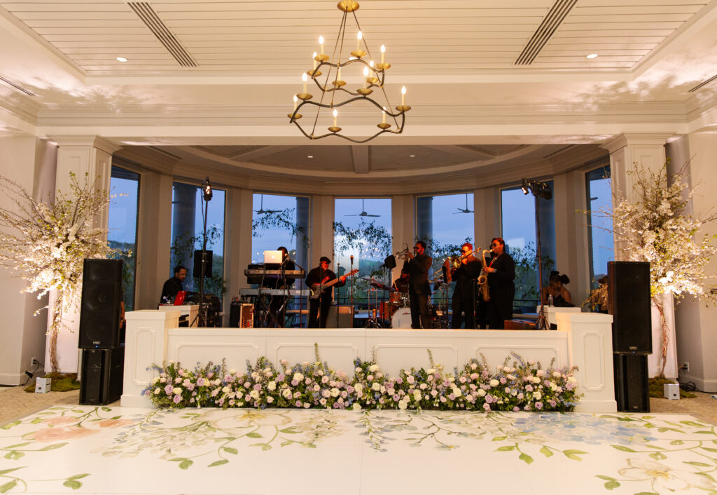 Lush and low floral meadows grow to accent the reception space of this spring wedding. Pastel color palette for spring wedding which shades of pink, purple, lavender, and cream. Mix of roses, peonies, and other delicate blooms, accented with greenery. Design by Rosemary & Finch Floral Design.