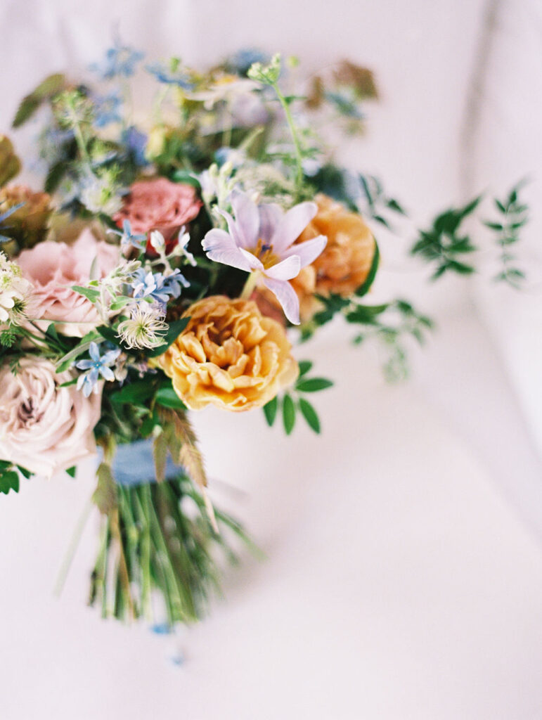 Whimsical bridal bouquet for fall Tennessee wedding. Soft whimsical floral design for unique fall wedding design. Fall wedding color palette in brown, soft blue, dusty rose, and muted greens. Whimsical florals featuring dried hydrangeas, tulips, delphinium, and grasses. Design by Rosemary & Finch Floral Design in Nashville, TN. 