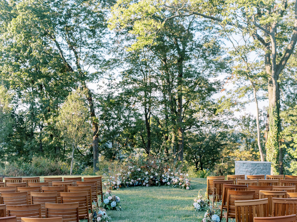 Lush garden floral meadow for fall wedding ceremony. Floral ground arch and organic aisle meadows with grassy textures and muted floral tones. Soft whimsical floral design for unique fall wedding design. Fall wedding color palette in brown, soft blue, dusty rose, and muted greens. Whimsical florals featuring dried hydrangeas, tulips, delphinium, and grasses. Design by Rosemary & Finch Floral Design in Nashville, TN. 