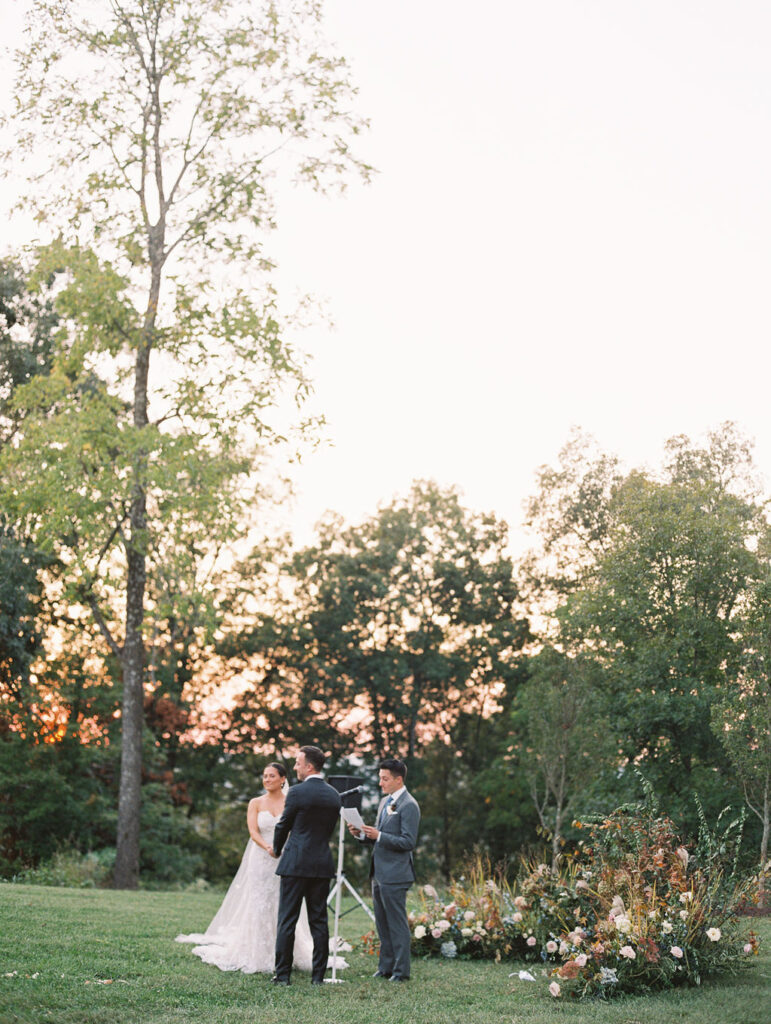 Lush garden floral meadow for fall wedding ceremony. Floral ground arch and organic aisle meadows with grassy textures and muted floral tones. Soft whimsical floral design for unique fall wedding design. Fall wedding color palette in brown, soft blue, dusty rose, and muted greens. Whimsical florals featuring dried hydrangeas, tulips, delphinium, and grasses. Design by Rosemary & Finch Floral Design in Nashville, TN. 