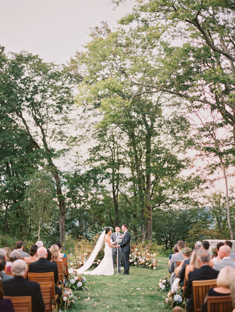 Lush garden floral meadow for fall wedding ceremony. Floral ground arch and organic aisle meadows with grassy textures and muted floral tones. Soft whimsical floral design for unique fall wedding design. Fall wedding color palette in brown, soft blue, dusty rose, and muted greens. Whimsical florals featuring dried hydrangeas, tulips, delphinium, and grasses. Design by Rosemary & Finch Floral Design in Nashville, TN. 