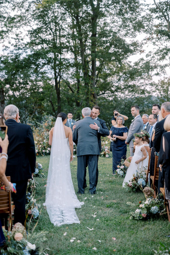 Lush garden floral meadow for fall wedding ceremony. Floral ground arch and organic aisle meadows with grassy textures and muted floral tones. Soft whimsical floral design for unique fall wedding design. Fall wedding color palette in brown, soft blue, dusty rose, and muted greens. Whimsical florals featuring dried hydrangeas, tulips, delphinium, and grasses. Design by Rosemary & Finch Floral Design in Nashville, TN. 