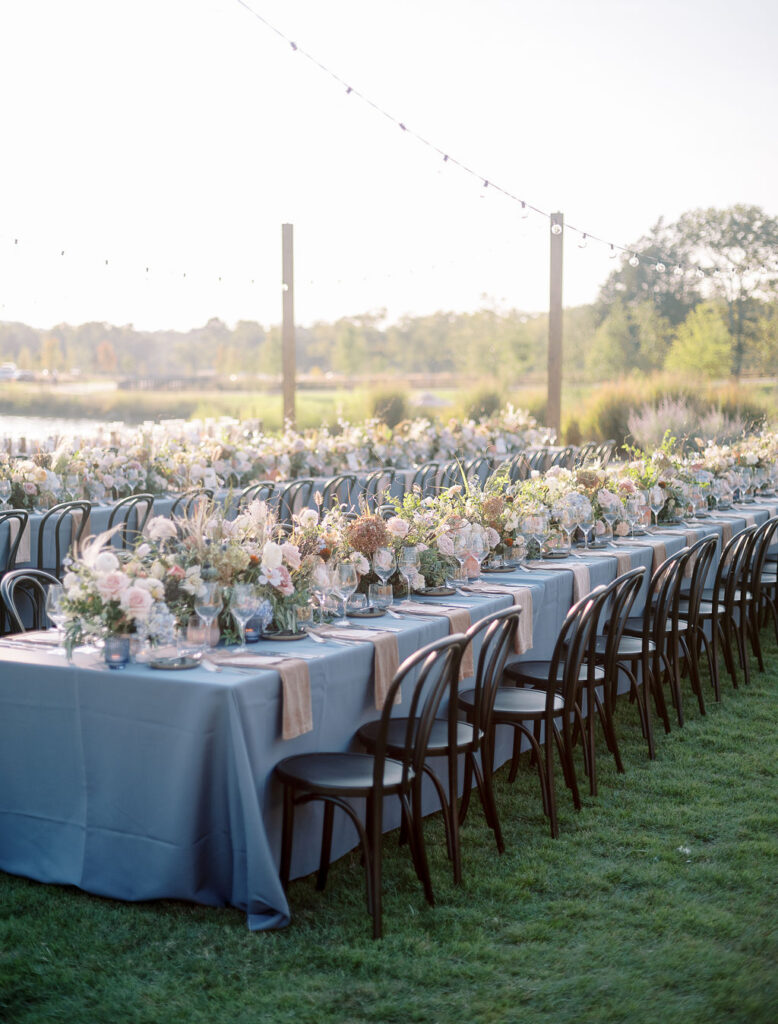 Lush floral table runner for fall wedding reception. Outdoor wedding reception at Southall Farm & Inn in Tennessee. Soft whimsical floral design for unique fall wedding design. Fall wedding color palette in brown, soft blue, dusty rose, and muted greens. Whimsical florals featuring dried hydrangeas, tulips, delphinium, and grasses. Design by Rosemary & Finch Floral Design in Nashville, TN. 