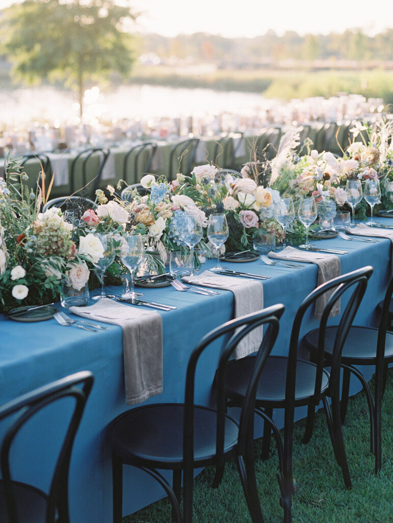 Lush floral table runner for fall wedding reception. Outdoor wedding reception at Southall Farm & Inn in Tennessee. Soft whimsical floral design for unique fall wedding design. Fall wedding color palette in brown, soft blue, dusty rose, and muted greens. Whimsical florals featuring dried hydrangeas, tulips, delphinium, and grasses. Design by Rosemary & Finch Floral Design in Nashville, TN. 