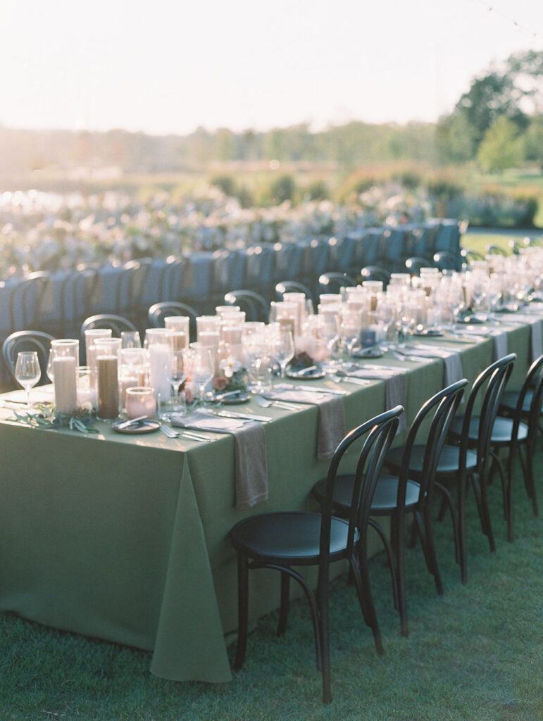 Candle heavy reception tables for outdoor wedding reception. Candlelight dinner for fall wedding with chocolate and taupe pillar candles. Curated candle design with blush and brown tone candles and votives. Soft whimsical floral design for unique fall wedding design. Fall wedding color palette in brown, soft blue, dusty rose, and muted greens. Design by Rosemary & Finch Floral Design in Nashville, TN. 