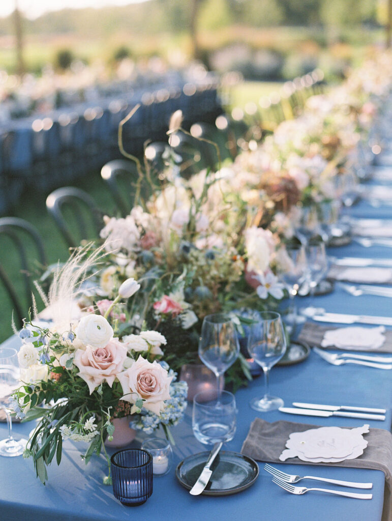 Lush floral table runner for fall wedding reception. Outdoor wedding reception at Southall Farm & Inn in Tennessee. Soft whimsical floral design for unique fall wedding design. Fall wedding color palette in brown, soft blue, dusty rose, and muted greens. Whimsical florals featuring dried hydrangeas, tulips, delphinium, and grasses. Design by Rosemary & Finch Floral Design in Nashville, TN. 