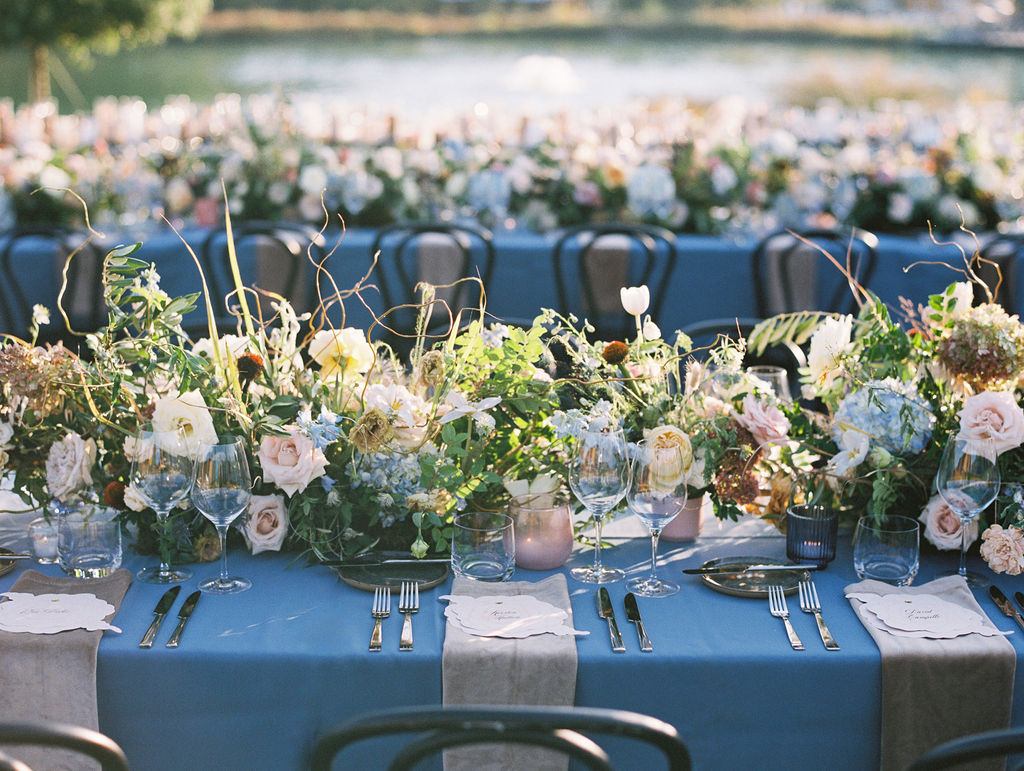 Lush floral table runner for fall wedding reception. Outdoor wedding reception at Southall Farm & Inn in Tennessee. Soft whimsical floral design for unique fall wedding design. Fall wedding color palette in brown, soft blue, dusty rose, and muted greens. Whimsical florals featuring dried hydrangeas, tulips, delphinium, and grasses. Design by Rosemary & Finch Floral Design in Nashville, TN. 