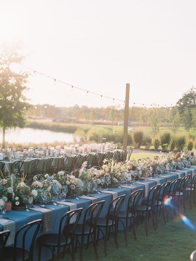 Lush floral table runner for fall wedding reception. Outdoor wedding reception at Southall Farm & Inn in Tennessee. Soft whimsical floral design for unique fall wedding design. Fall wedding color palette in brown, soft blue, dusty rose, and muted greens. Whimsical florals featuring dried hydrangeas, tulips, delphinium, and grasses. Design by Rosemary & Finch Floral Design in Nashville, TN. 