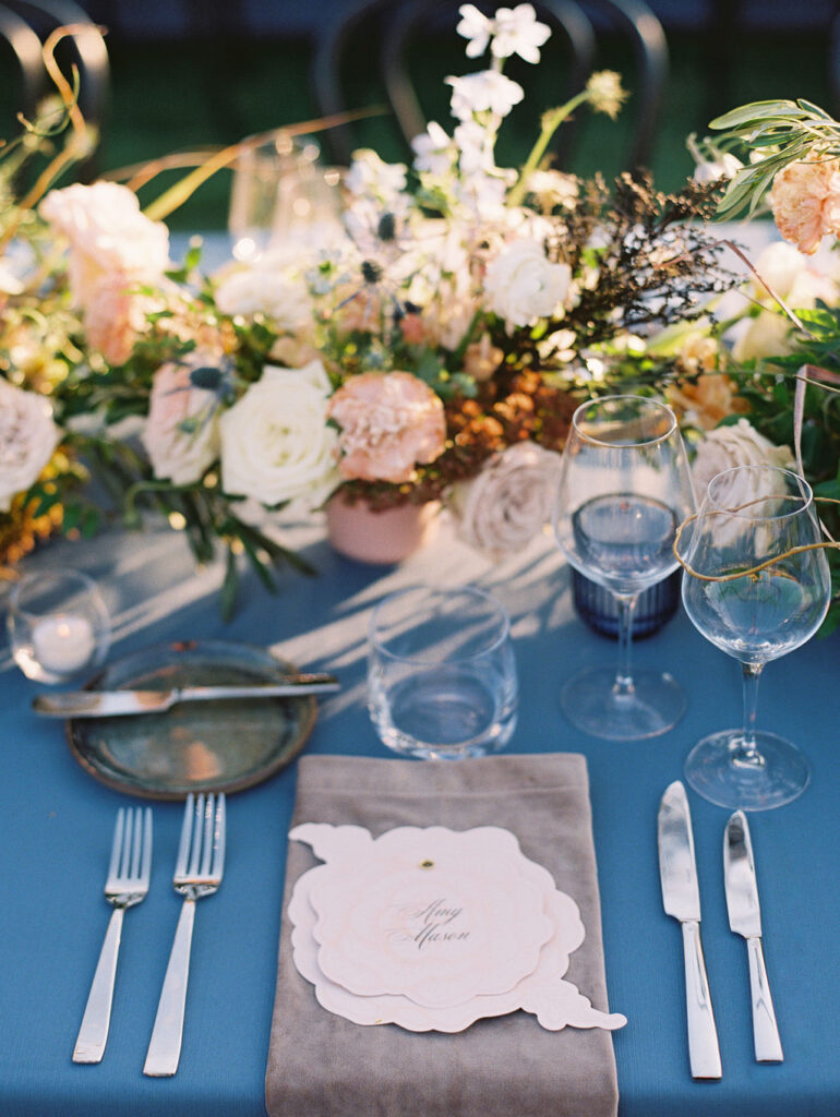 Lush floral table runner for fall wedding reception. Outdoor wedding reception at Southall Farm & Inn in Tennessee. Soft whimsical floral design for unique fall wedding design. Fall wedding color palette in brown, soft blue, dusty rose, and muted greens. Whimsical florals featuring dried hydrangeas, tulips, delphinium, and grasses. Design by Rosemary & Finch Floral Design in Nashville, TN. 