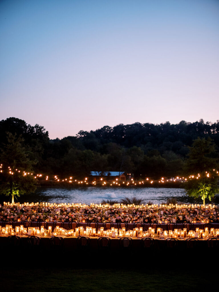 Candle heavy reception tables for outdoor wedding reception. Candlelight dinner for fall wedding with chocolate and taupe pillar candles. Curated candle design with blush and brown tone candles and votives. Soft whimsical floral design for unique fall wedding design. Fall wedding color palette in brown, soft blue, dusty rose, and muted greens. Design by Rosemary & Finch Floral Design in Nashville, TN. 