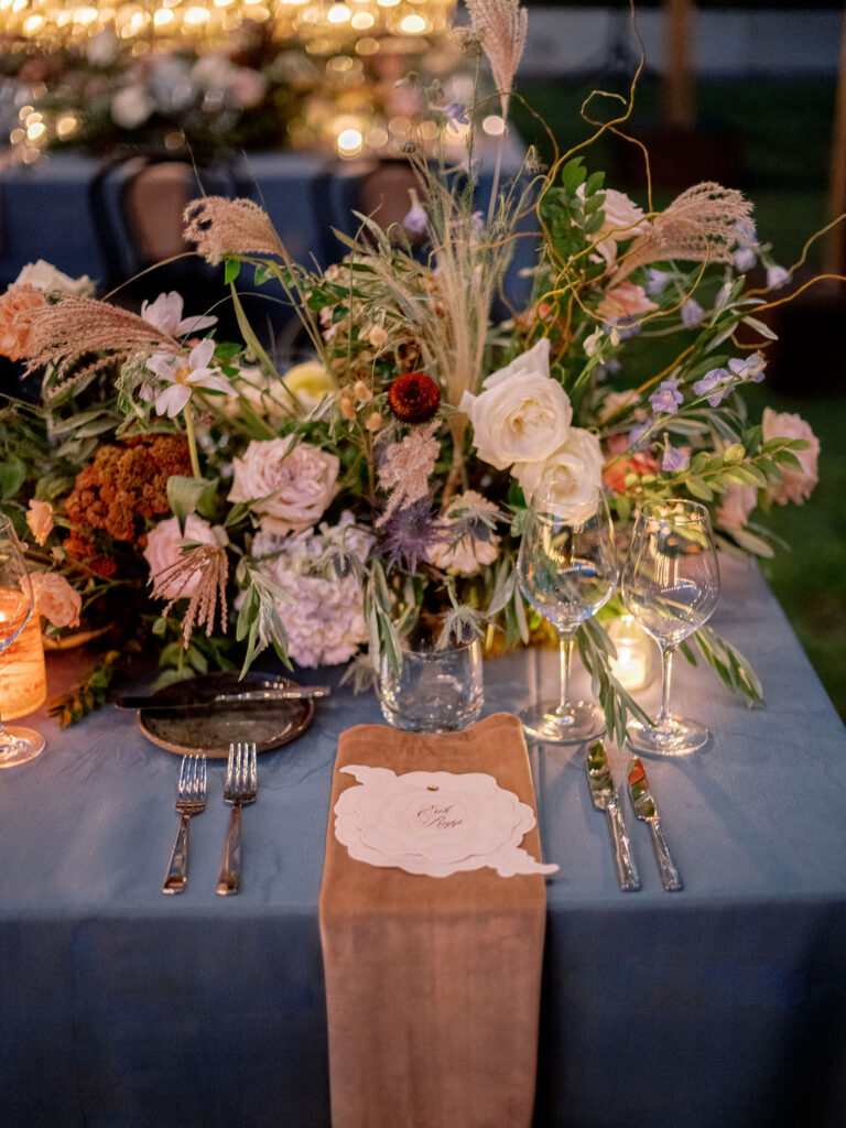 Lush floral table runner for fall wedding reception. Outdoor wedding reception at Southall Farm & Inn in Tennessee. Soft whimsical floral design for unique fall wedding design. Fall wedding color palette in brown, soft blue, dusty rose, and muted greens. Whimsical florals featuring dried hydrangeas, tulips, delphinium, and grasses. Design by Rosemary & Finch Floral Design in Nashville, TN. 