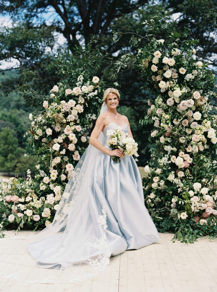 Epic ceremony backdrop for fall wedding at Blackberry Farms. Lush broken arch floral design for wedding ceremony backdrop. Garden inspired growing floral in colors of cream, white, blush, and green. Full coverage floral aisle for wedding ceremony. Floral meadows with petal heavy roses. Floral heavy flora design with elegant and whimsical design. Destination wedding at Blackberry Farm. Design by Rosemary & Finch Floral Design in Nashville, TN. 