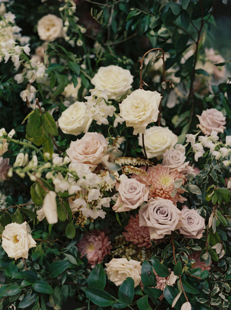 Epic ceremony backdrop for fall wedding at Blackberry Farms. Lush broken arch floral design for wedding ceremony backdrop. Garden inspired growing floral in colors of cream, white, blush, and green. Full coverage floral aisle for wedding ceremony. Floral meadows with petal heavy roses. Floral heavy flora design with elegant and whimsical design. Destination wedding at Blackberry Farm. Design by Rosemary & Finch Floral Design in Nashville, TN. 