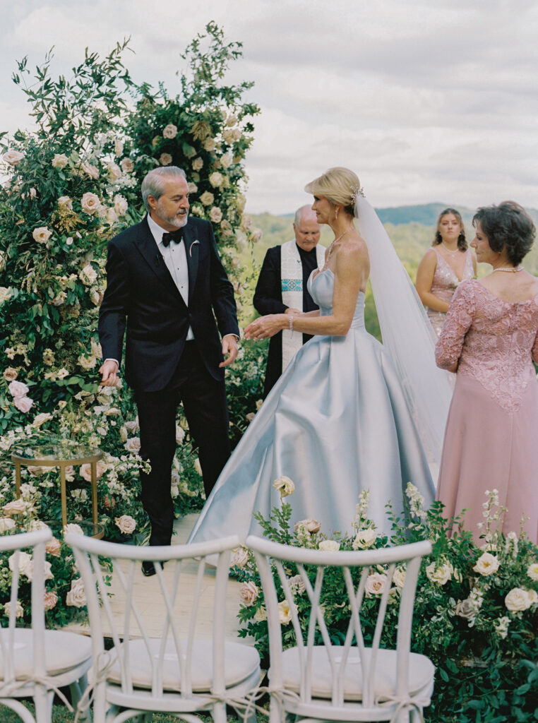 Epic ceremony backdrop for fall wedding at Blackberry Farms. Lush broken arch floral design for wedding ceremony backdrop. Garden inspired growing floral in colors of cream, white, blush, and green. Full coverage floral aisle for wedding ceremony. Floral meadows with petal heavy roses. Floral heavy flora design with elegant and whimsical design. Destination wedding at Blackberry Farm. Design by Rosemary & Finch Floral Design in Nashville, TN. 