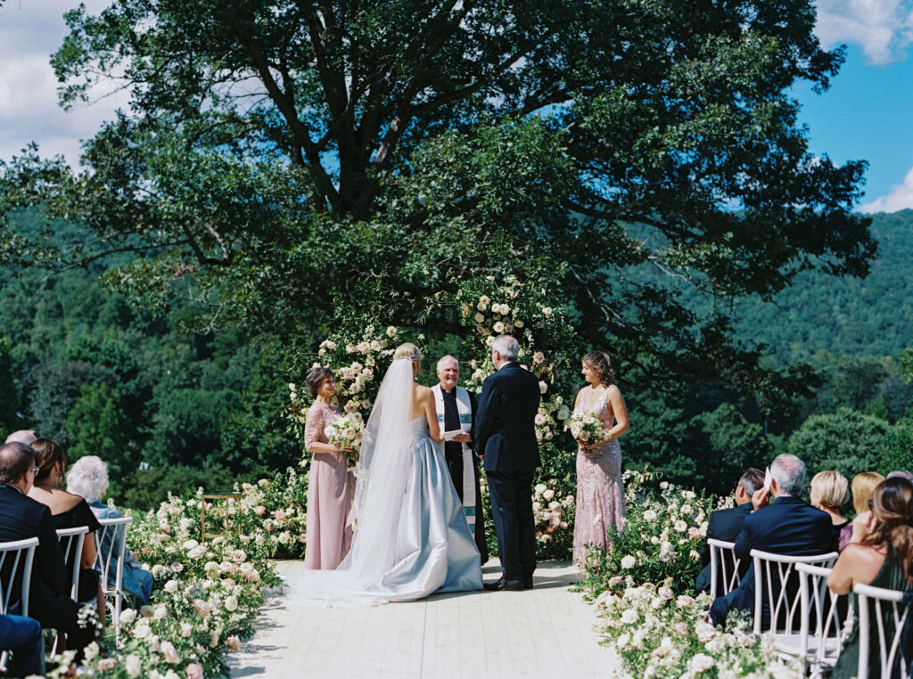 Epic ceremony backdrop for fall wedding at Blackberry Farms. Lush broken arch floral design for wedding ceremony backdrop. Garden inspired growing floral in colors of cream, white, blush, and green. Full coverage floral aisle for wedding ceremony. Floral meadows with petal heavy roses. Floral heavy flora design with elegant and whimsical design. Destination wedding at Blackberry Farm. Design by Rosemary & Finch Floral Design in Nashville, TN. 