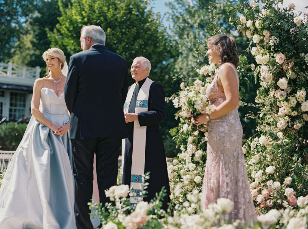 Epic ceremony backdrop for fall wedding at Blackberry Farms. Lush broken arch floral design for wedding ceremony backdrop. Garden inspired growing floral in colors of cream, white, blush, and green. Full coverage floral aisle for wedding ceremony. Floral meadows with petal heavy roses. Floral heavy flora design with elegant and whimsical design. Destination wedding at Blackberry Farm. Design by Rosemary & Finch Floral Design in Nashville, TN. 