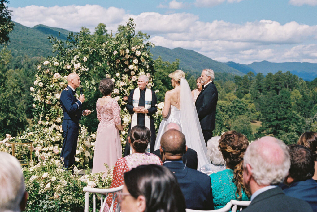 Epic ceremony backdrop for fall wedding at Blackberry Farms. Lush broken arch floral design for wedding ceremony backdrop. Garden inspired growing floral in colors of cream, white, blush, and green. Full coverage floral aisle for wedding ceremony. Floral meadows with petal heavy roses. Floral heavy flora design with elegant and whimsical design. Destination wedding at Blackberry Farm. Design by Rosemary & Finch Floral Design in Nashville, TN. 