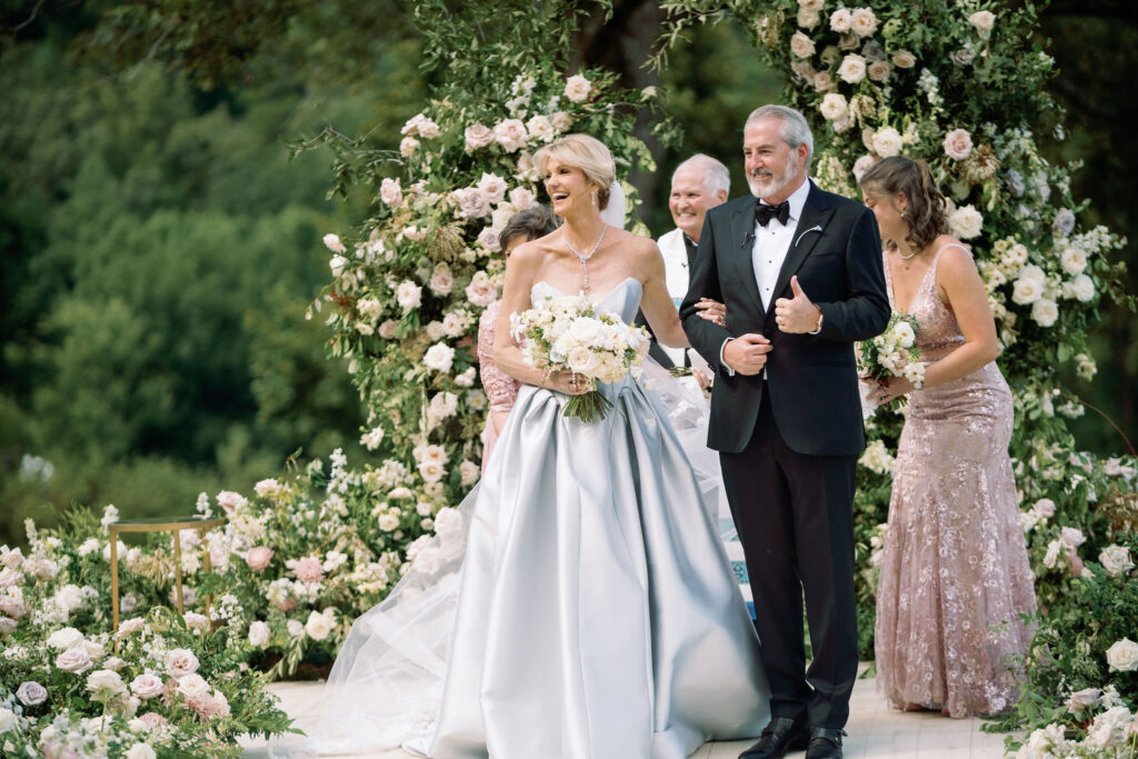 Epic ceremony backdrop for fall wedding at Blackberry Farms. Lush broken arch floral design for wedding ceremony backdrop. Garden inspired growing floral in colors of cream, white, blush, and green. Full coverage floral aisle for wedding ceremony. Floral meadows with petal heavy roses. Floral heavy flora design with elegant and whimsical design. Destination wedding at Blackberry Farm. Design by Rosemary & Finch Floral Design in Nashville, TN. 