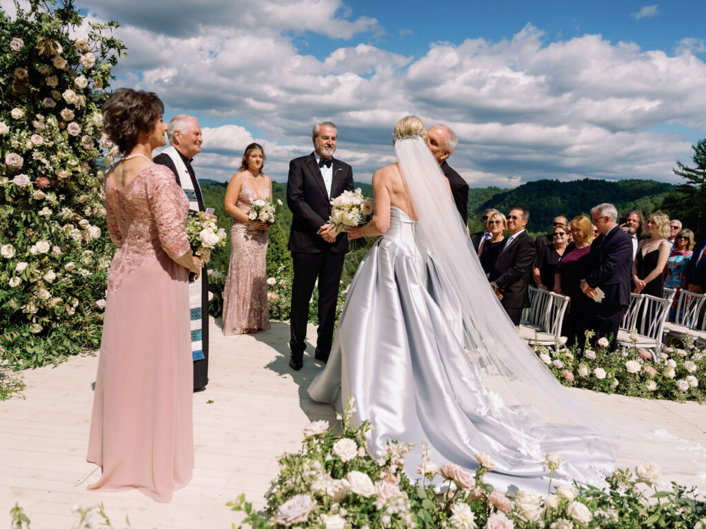 Epic ceremony backdrop for fall wedding at Blackberry Farms. Lush broken arch floral design for wedding ceremony backdrop. Garden inspired growing floral in colors of cream, white, blush, and green. Full coverage floral aisle for wedding ceremony. Floral meadows with petal heavy roses. Floral heavy flora design with elegant and whimsical design. Destination wedding at Blackberry Farm. Design by Rosemary & Finch Floral Design in Nashville, TN. 