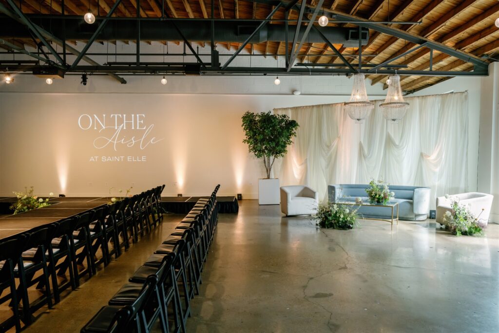 Lush, garden-inspired cocktail hour floral arrangement for bridal fashion show in Nashville, TN. The flowers overflow with texture and movement, featuring Queen Anne’s lace, oncidium orchids, lisianthus, amaranthus, and airy grasses. With earthy greens, soft whites, golden yellow, and touches of mauve and burgundy, the flowers spill naturally, creating a whimsical, meadow-like focal point for a modern lounge setting. Design by Rosemary & Finch Floral Design in Nashville, TN.
