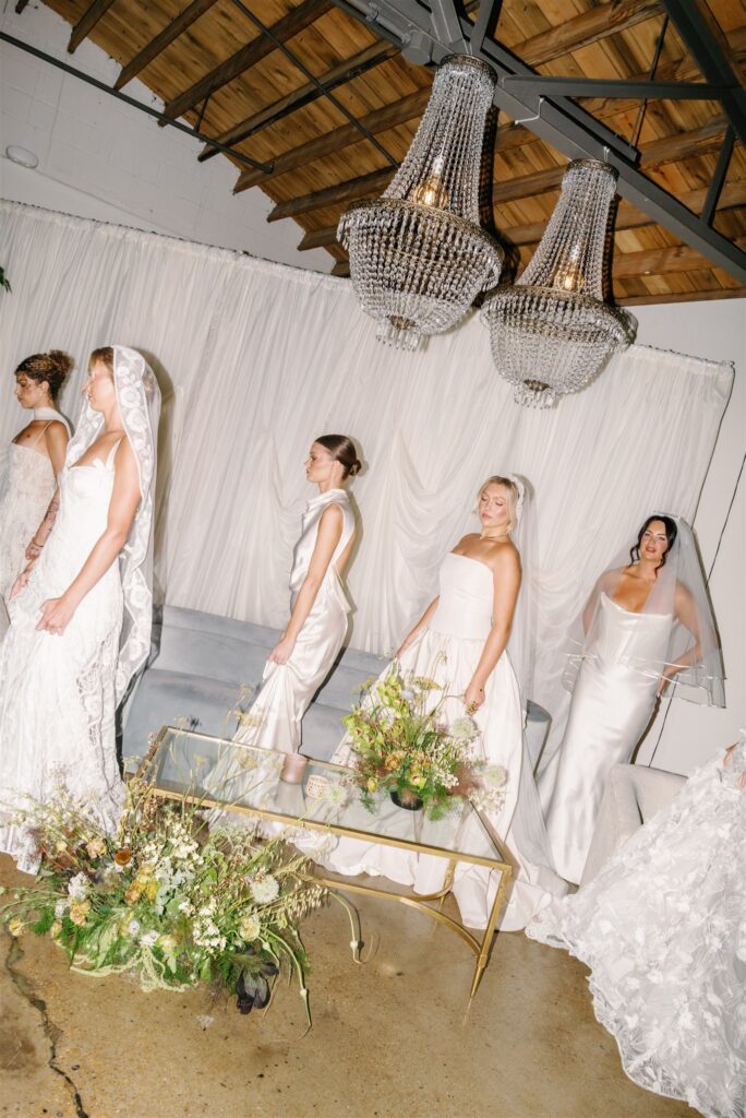 Lush, garden-inspired florals for summer bridal fashion show in Nashville, TN. Textured floral arrangements consist of Queen Anne’s lace, oncidium orchids, blue nigella, lisianthus, zinnias, amaranthus, allium, coneflower, smokebush, forget me nots, ferns and airy grasses. With earthy greens, soft whites, yellows, mauve and burgundy, the flowers spill out and showcase a modern and editorial focal point for bridal portraits. Design by Rosemary & Finch Floral Design in Nashville, TN.