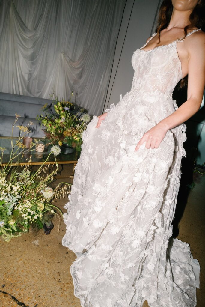 Lush, garden-inspired florals for summer bridal fashion show in Nashville, TN. Textured floral arrangements consist of Queen Anne’s lace, oncidium orchids, blue nigella, lisianthus, zinnias, amaranthus, allium, coneflower, smokebush, forget me nots, ferns and airy grasses. With earthy greens, soft whites, yellows, mauve and burgundy, the flowers spill out and showcase a modern and editorial focal point for bridal portraits. Design by Rosemary & Finch Floral Design in Nashville, TN.