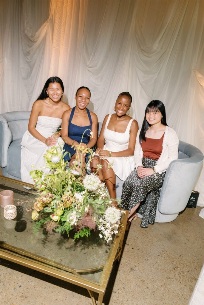 Lush, garden-inspired cocktail hour floral arrangement for bridal fashion show in Nashville, TN. The flowers overflow with texture and movement, featuring Queen Anne’s lace, oncidium orchids, lisianthus, amaranthus, and airy grasses. With earthy greens, soft whites, golden yellow, and touches of mauve and burgundy, the flowers spill naturally, creating a whimsical, meadow-like focal point for a modern lounge setting. Design by Rosemary & Finch Floral Design in Nashville, TN.