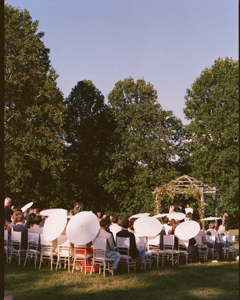 Elegant, organic and untamed outdoor wedding ceremony at Blackberry Farms featured in Vogue. Whimsical, grassy meadows line the aisle and floral accents are highlighted with white cosmos, green mist, solidago, yarrow, scabiosa and grasses. Pergola is covered in lush greenery with soft touches of cream roses and wispy meadows at the base. Design by Rosemary & Finch Floral Design in Nashville, TN. 