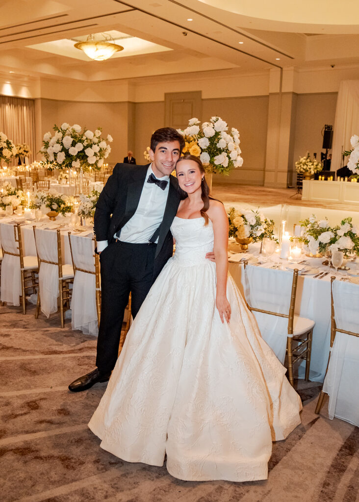 Stunning reception florals for summer wedding reception in Buckhead, Atlanta. All-white floral centerpieces featuring cloud roses, playa blanca roses, peonies, ranunculus, double tulips and lisianthus. Minimal greenery complements beautiful floral table arrangements and bud vases. Elevated all-white rose centerpieces scattered throughout reception. Design by Rosemary & Finch Floral Design in Nashville, TN.