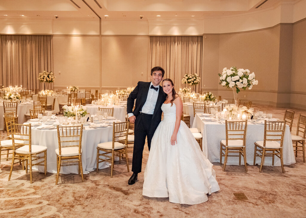 Stunning reception florals for summer wedding reception in Buckhead, Atlanta. All-white floral centerpieces featuring cloud roses, playa blanca roses, peonies, ranunculus, double tulips and lisianthus. Minimal greenery complements beautiful floral table arrangements and bud vases. Elevated all-white rose centerpieces scattered throughout reception. Design by Rosemary & Finch Floral Design in Nashville, TN.