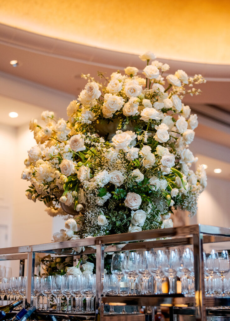 Stunning cocktail hour florals for wedding reception in Buckhead, Atlanta. All-white florals featuring cloud roses, playa blanca roses, peonies, ranunculus, delphinium, baby’s breath, double tulips and lisianthus. Soft and romantic floral display for summer wedding. Design by Rosemary & Finch Floral Design in Nashville, TN.