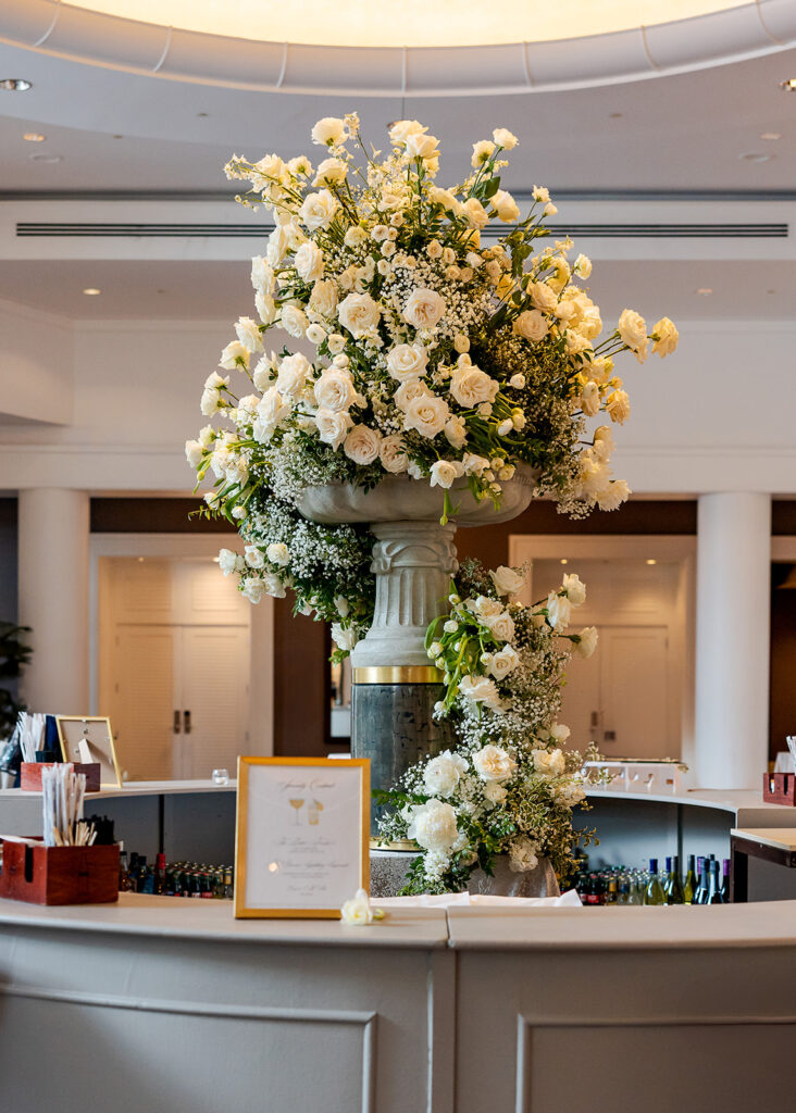 Stunning cocktail hour florals for wedding reception in Buckhead, Atlanta. All-white florals featuring cloud roses, playa blanca roses, peonies, ranunculus, delphinium, baby’s breath, double tulips and lisianthus. Soft and romantic floral display for summer wedding. Design by Rosemary & Finch Floral Design in Nashville, TN.