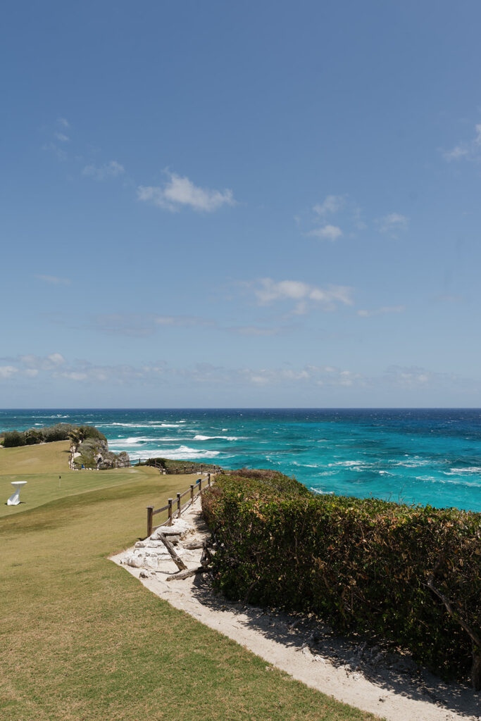 Lush and romantic ceremony chuppah florals for beachfront wedding in the Bahamas. The chuppah highlights garden roses, hydrangeas, delphinium, spray roses, baby’s breath, chrysanthemums, oncidium, wisteria, tulips and a mixture of airy greens to create an elegant and dramatic focal point. Layered textures and soft movement blend seamlessly with lush aisle meadows featuring the same flowers as the chuppah. Design by Rosemary & Finch Floral Design in Nashville, TN.