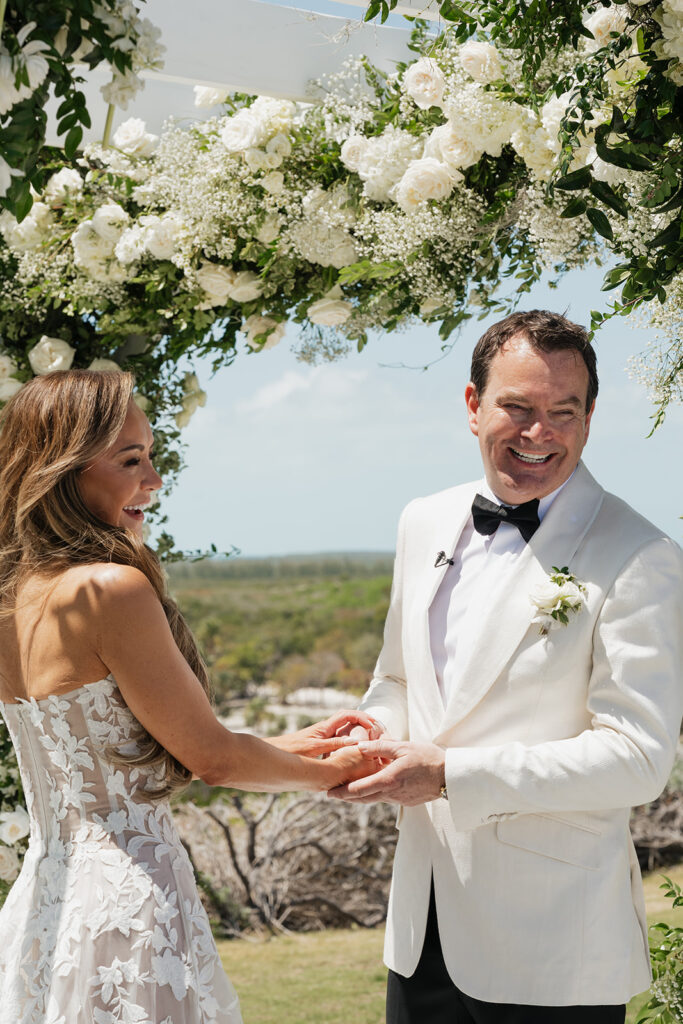 Lush and romantic ceremony chuppah florals for beachfront wedding in the Bahamas. The chuppah highlights garden roses, hydrangeas, delphinium, spray roses, baby’s breath, chrysanthemums, oncidium, wisteria, tulips and a mixture of airy greens to create an elegant and dramatic focal point. Layered textures and soft movement blend seamlessly with lush aisle meadows featuring the same flowers as the chuppah. Design by Rosemary & Finch Floral Design in Nashville, TN.