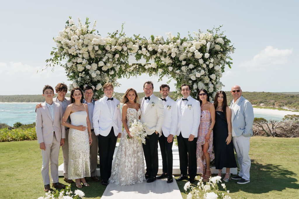 Lush and romantic ceremony chuppah florals for beachfront wedding in the Bahamas. The chuppah highlights garden roses, hydrangeas, delphinium, spray roses, baby’s breath, chrysanthemums, oncidium, wisteria, tulips and a mixture of airy greens to create an elegant and dramatic focal point. Layered textures and soft movement blend seamlessly with lush aisle meadows featuring the same flowers as the chuppah. Design by Rosemary & Finch Floral Design in Nashville, TN.
