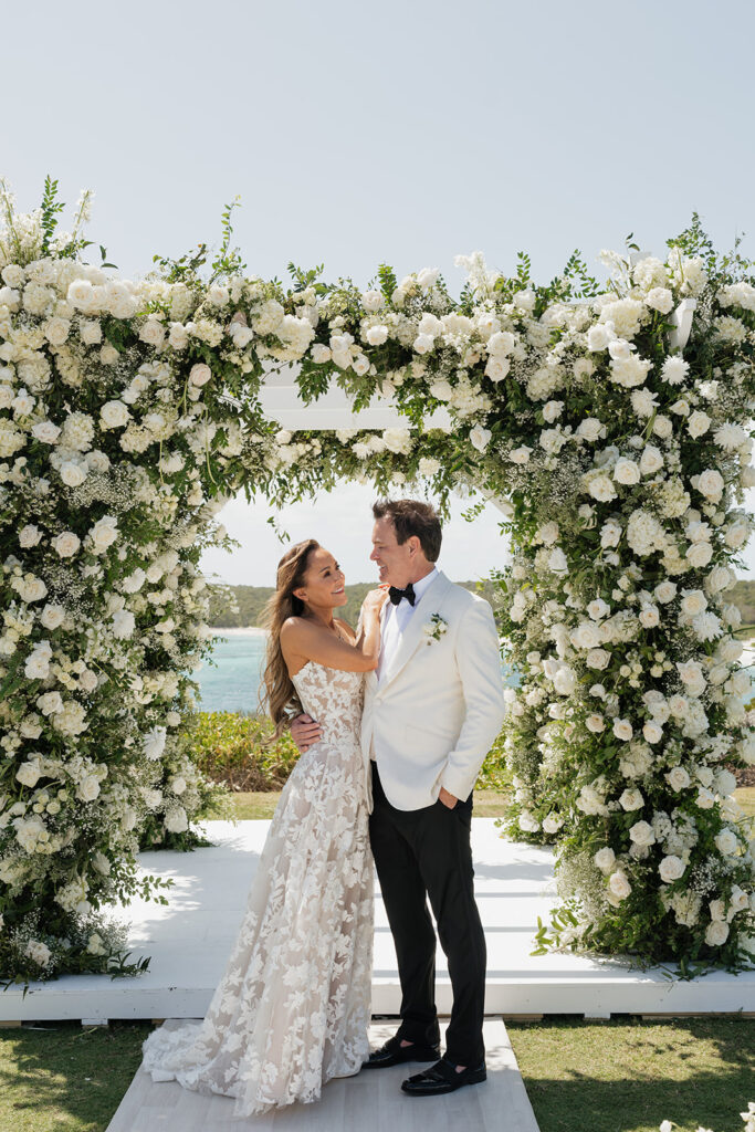 Lush and romantic ceremony chuppah florals for beachfront wedding in the Bahamas. The chuppah highlights garden roses, hydrangeas, delphinium, spray roses, baby’s breath, chrysanthemums, oncidium, wisteria, tulips and a mixture of airy greens to create an elegant and dramatic focal point. Layered textures and soft movement blend seamlessly with lush aisle meadows featuring the same flowers as the chuppah. Design by Rosemary & Finch Floral Design in Nashville, TN.