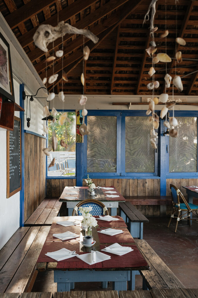 Simple, elegant arrangements for a beachfront wedding welcome party in the Bahamas. Romantic all-white florals create a timeless look highlighted with roses, hydrangeas, tulips, ranunculus, delphinium and greens. Design by Rosemary and Finch Floral Design in Nashville, TN.