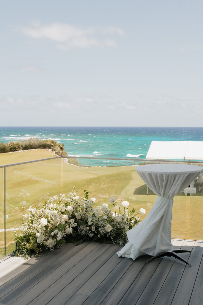 Simple, romantic all white floral bud vase arrangements for stunning bahamas cocktail hour. Bud vases are accompanied by all-white statement piece arrangements featuring garden roses, hydrangeas, spray roses, waxflower, delphinium, ranunculus, tulips, oncidium orchids, lisianthus, tweedia, lilac, sweet peas and are accented by a mix of greenery. Design by Rosemary & Finch Floral Design in Nashville, TN. 
