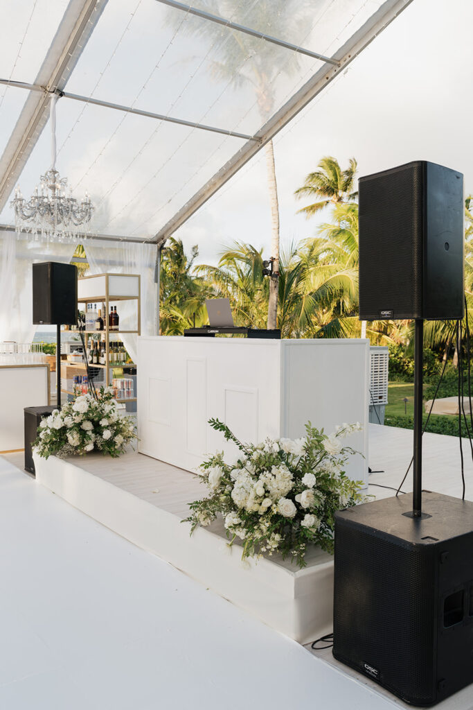 Simple, romantic all white floral bud vase arrangements for stunning bahamas cocktail hour. Bud vases are accompanied by all-white statement piece arrangements featuring garden roses, hydrangeas, spray roses, waxflower, delphinium, ranunculus, tulips, oncidium orchids, lisianthus, tweedia, lilac, sweet peas and are accented by a mix of greenery. Design by Rosemary & Finch Floral Design in Nashville, TN. 
