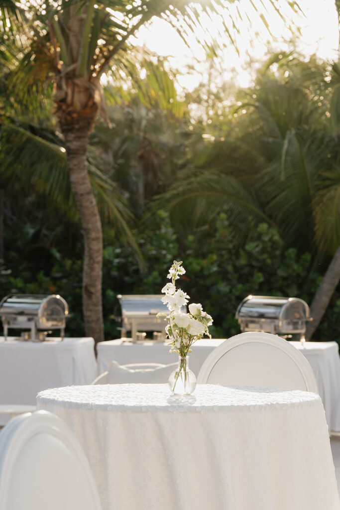 Simple, romantic all white floral bud vase arrangements for stunning bahamas cocktail hour. Bud vases are accompanied by all-white statement piece arrangements featuring garden roses, hydrangeas, spray roses, waxflower, delphinium, ranunculus, tulips, oncidium orchids, lisianthus, tweedia, lilac, sweet peas and are accented by a mix of greenery. Design by Rosemary & Finch Floral Design in Nashville, TN. 
