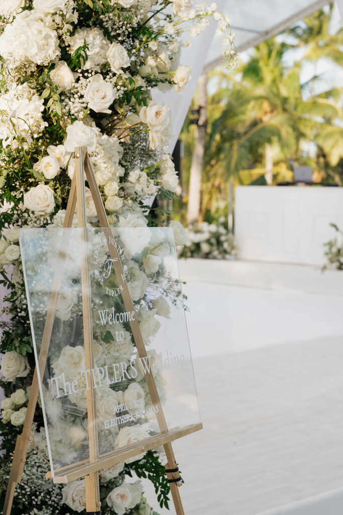 Simple, romantic all white floral bud vase arrangements for stunning bahamas cocktail hour. Bud vases are accompanied by all-white statement piece arrangements featuring garden roses, hydrangeas, spray roses, waxflower, delphinium, ranunculus, tulips, oncidium orchids, lisianthus, tweedia, lilac, sweet peas and are accented by a mix of greenery. Design by Rosemary & Finch Floral Design in Nashville, TN. 
